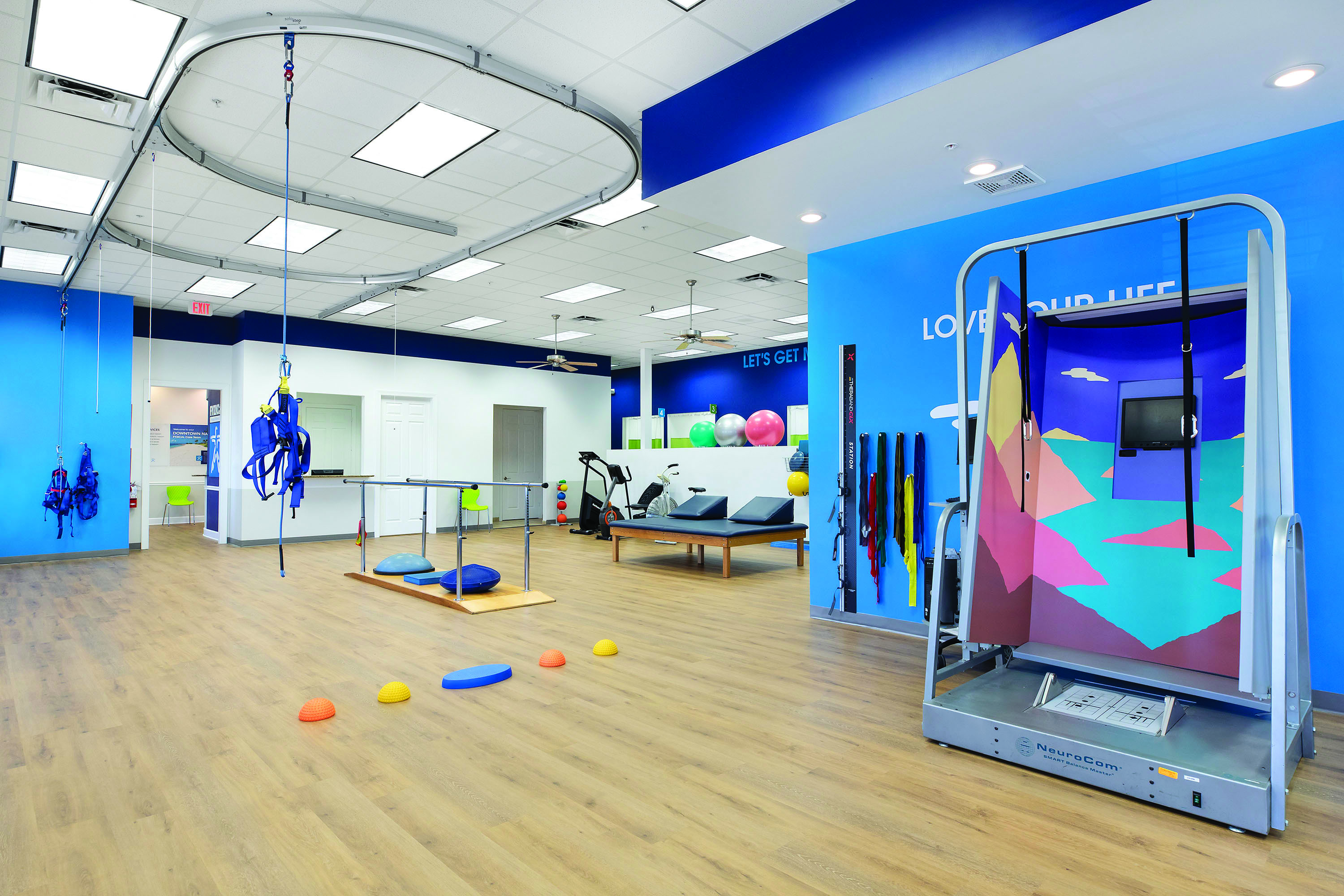 FYZICAL Clinic Interior with Balance overhead rails, harness, CDP machine, parallel bars and various physical therapy equipment